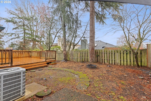 view of yard with central AC and a wooden deck