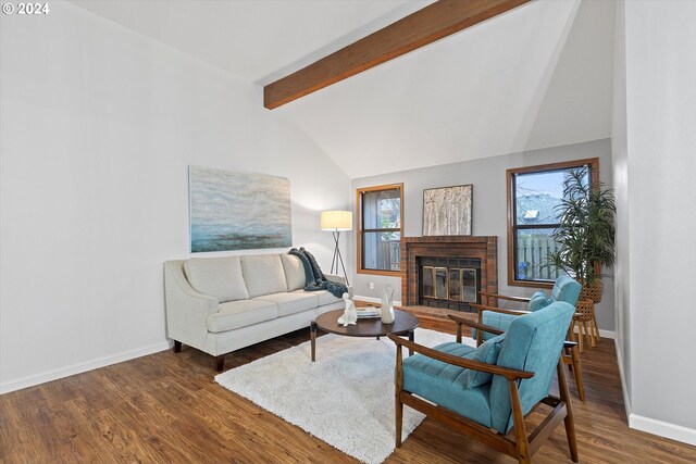 living room featuring a fireplace, lofted ceiling with beams, dark wood-type flooring, and a healthy amount of sunlight