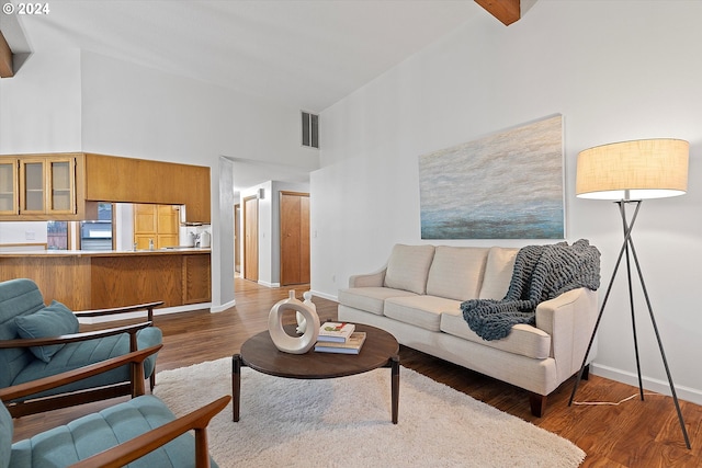 living room with dark hardwood / wood-style floors, high vaulted ceiling, and beam ceiling