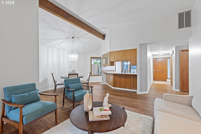 living room featuring hardwood / wood-style floors, an inviting chandelier, beam ceiling, and high vaulted ceiling