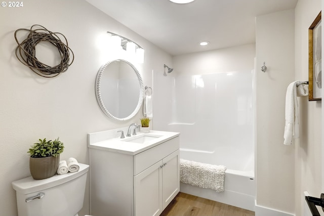 full bath with recessed lighting, shower / washtub combination, wood finished floors, toilet, and vanity