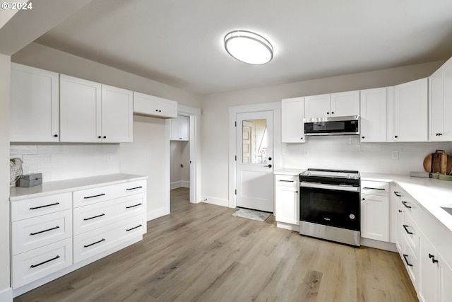 kitchen featuring light wood-style floors, white cabinetry, appliances with stainless steel finishes, and tasteful backsplash