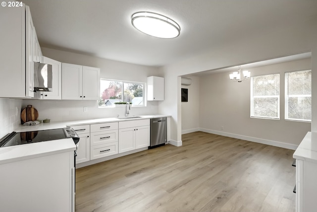 kitchen with sink, light wood-type flooring, white cabinetry, stainless steel appliances, and pendant lighting