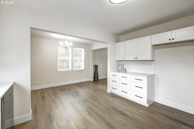 kitchen featuring a chandelier, light hardwood / wood-style flooring, hanging light fixtures, and white cabinetry