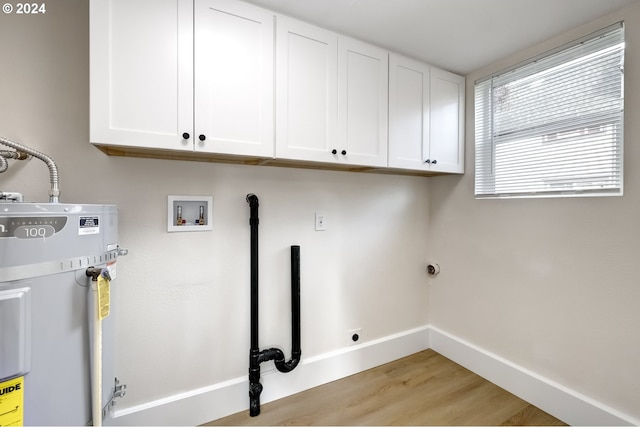 clothes washing area featuring light wood finished floors, hookup for an electric dryer, baseboards, secured water heater, and cabinet space