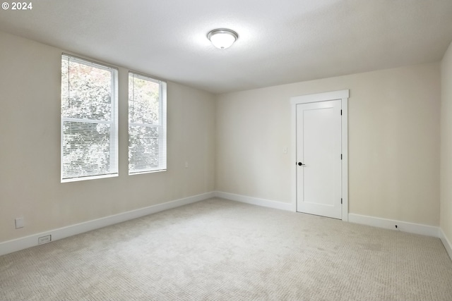 unfurnished room featuring carpet flooring and baseboards