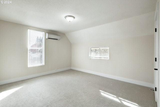 bonus room featuring lofted ceiling, carpet, a wall mounted AC, and a healthy amount of sunlight