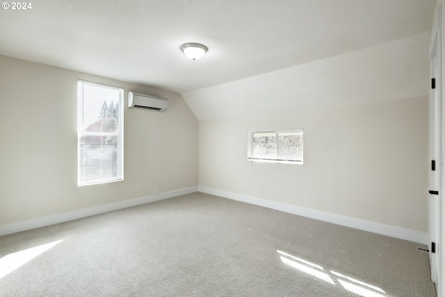 additional living space featuring lofted ceiling, a wealth of natural light, carpet, and a wall unit AC