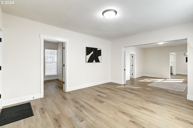 empty room featuring light wood-type flooring and baseboards