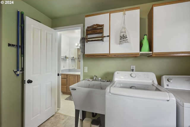 laundry room featuring cabinets, washer and dryer, and sink