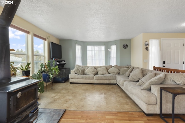 living room featuring hardwood / wood-style floors, a textured ceiling, and a wood stove