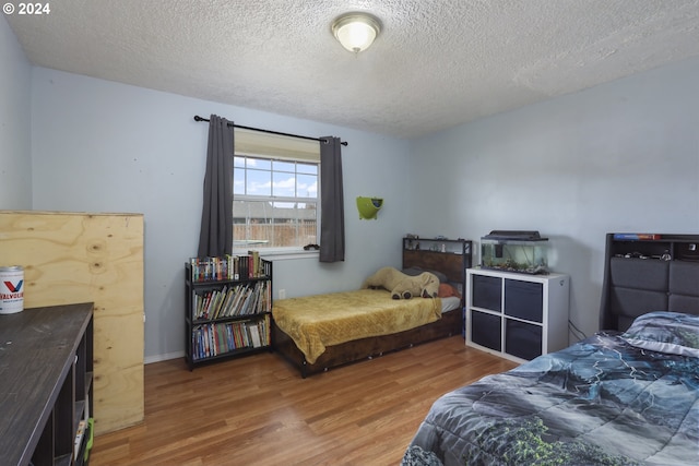 bedroom featuring hardwood / wood-style floors and a textured ceiling