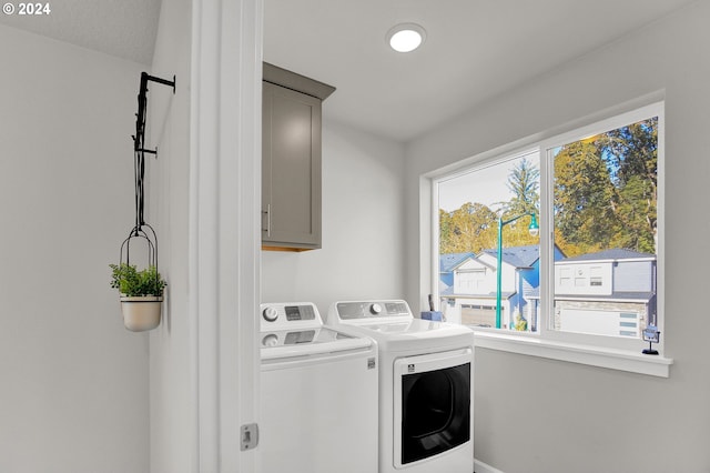 clothes washing area with independent washer and dryer and cabinets