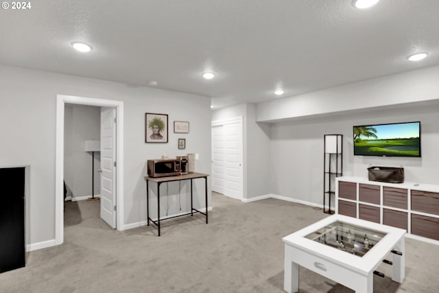 rec room featuring light colored carpet and a textured ceiling