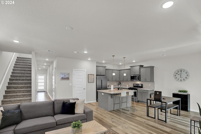 living room with a textured ceiling and light hardwood / wood-style flooring