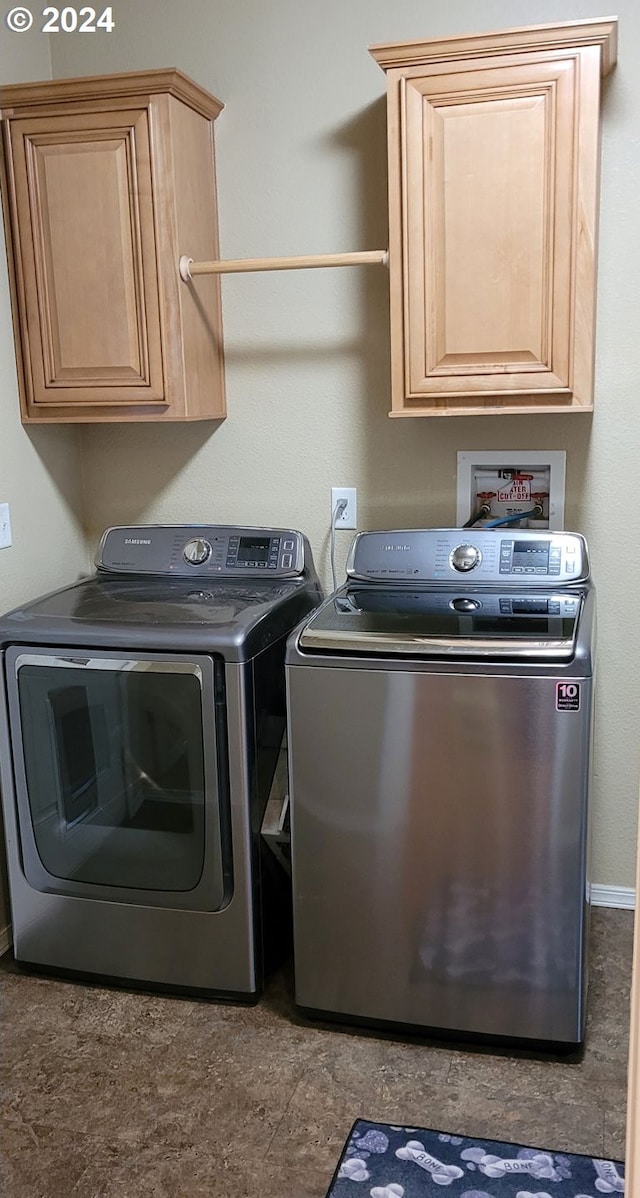 laundry room featuring separate washer and dryer and cabinets