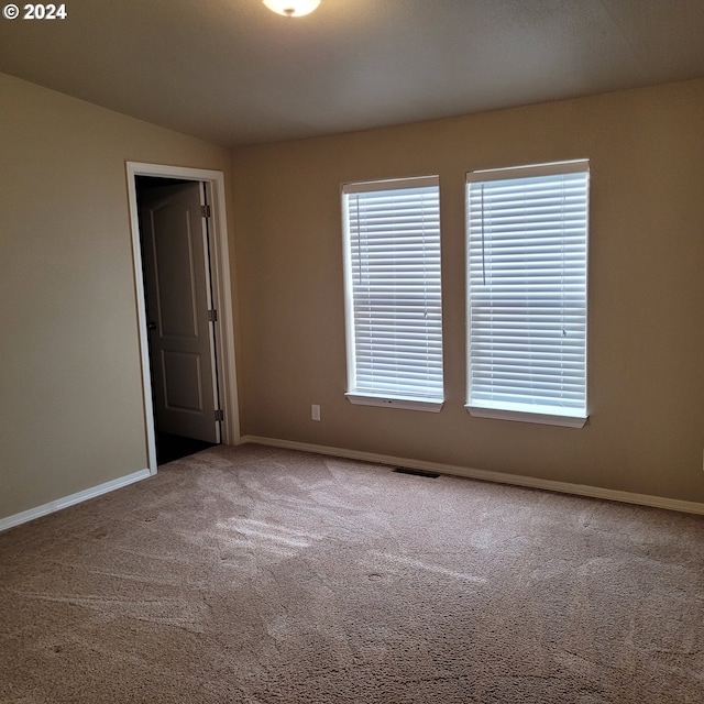 unfurnished room featuring carpet flooring and vaulted ceiling