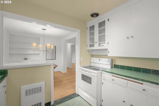 kitchen with tile counters, white electric range, white cabinets, and hanging light fixtures