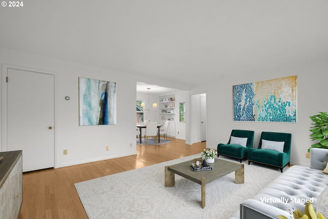 living room with built in shelves and hardwood / wood-style floors