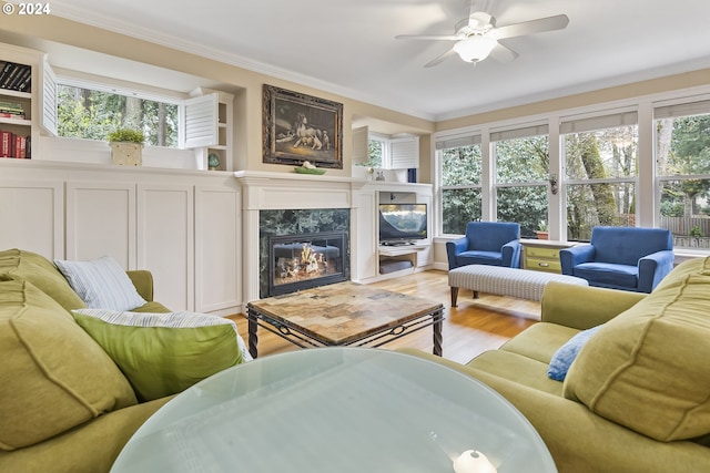 living room with a high end fireplace, plenty of natural light, and light hardwood / wood-style floors