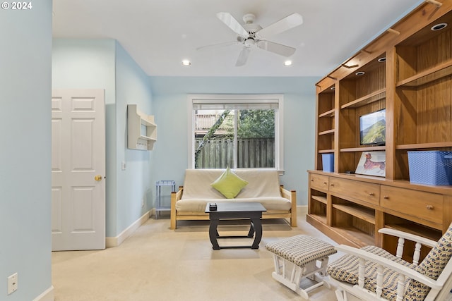 sitting room featuring light colored carpet and ceiling fan