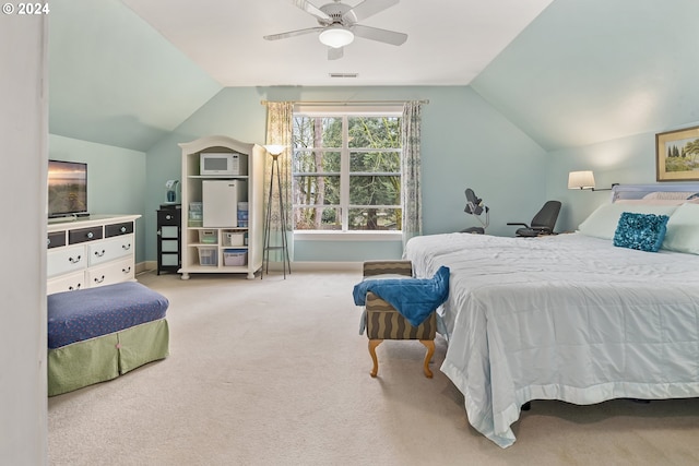 bedroom with ceiling fan, lofted ceiling, and light colored carpet