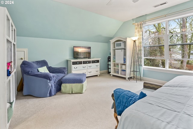 bedroom with ceiling fan, vaulted ceiling, and light colored carpet