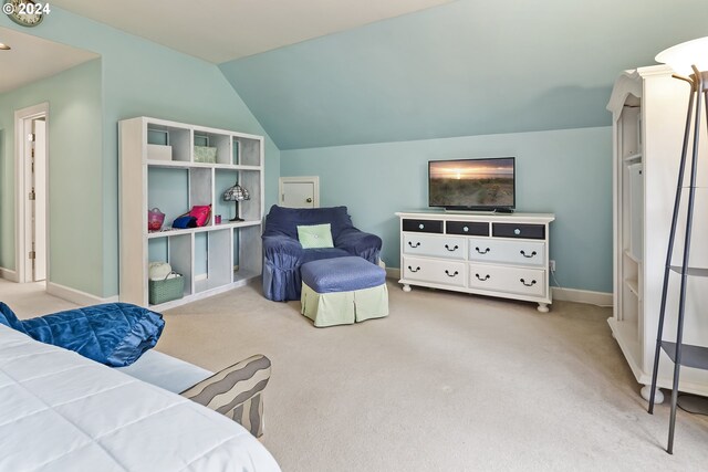 bedroom featuring light colored carpet and vaulted ceiling