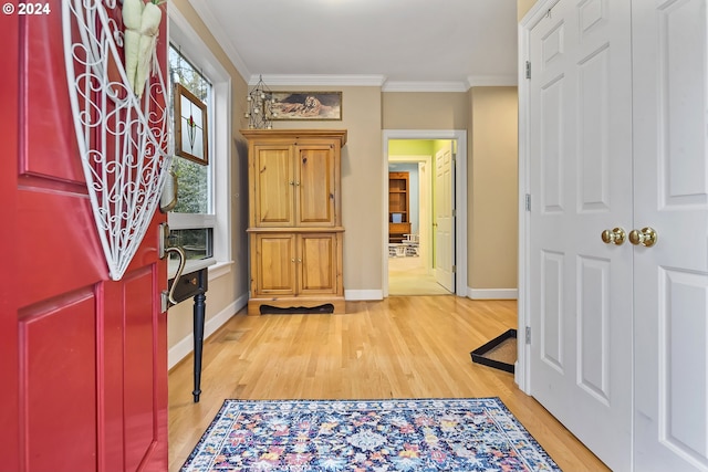 entryway with ornamental molding and light hardwood / wood-style flooring