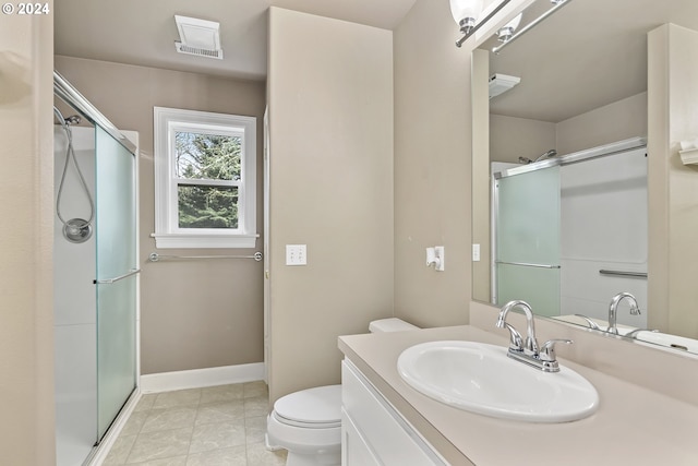 bathroom with vanity, tile floors, a shower with door, and toilet