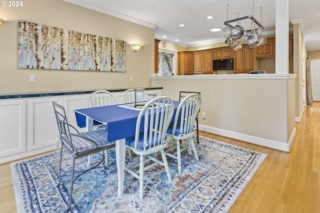 dining area featuring ornamental molding, a chandelier, and light hardwood / wood-style flooring