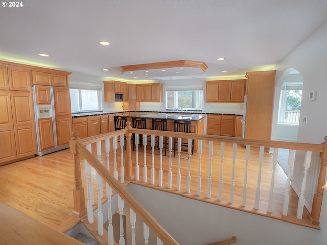 kitchen featuring built in appliances, light hardwood / wood-style flooring, and a healthy amount of sunlight