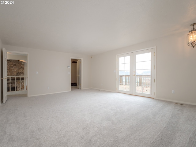 spare room with light carpet and french doors