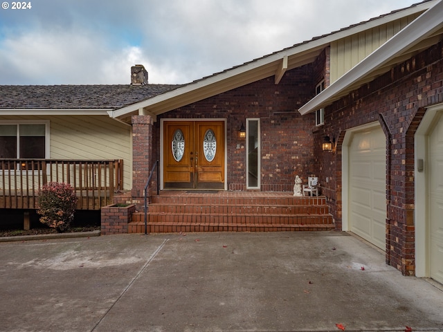 entrance to property featuring a porch and a garage