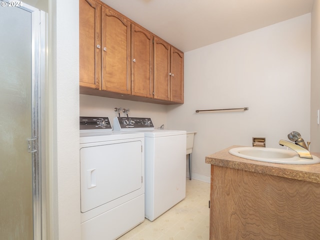 laundry area featuring washer and clothes dryer, cabinets, and sink