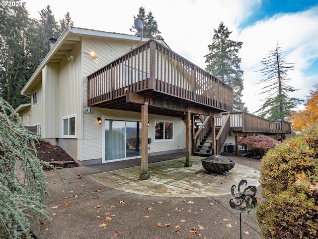 rear view of house with a deck, a patio area, and a fire pit