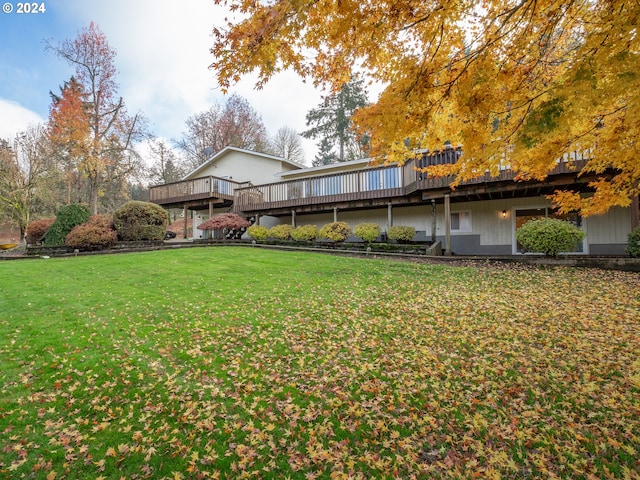 rear view of house featuring a yard and a wooden deck