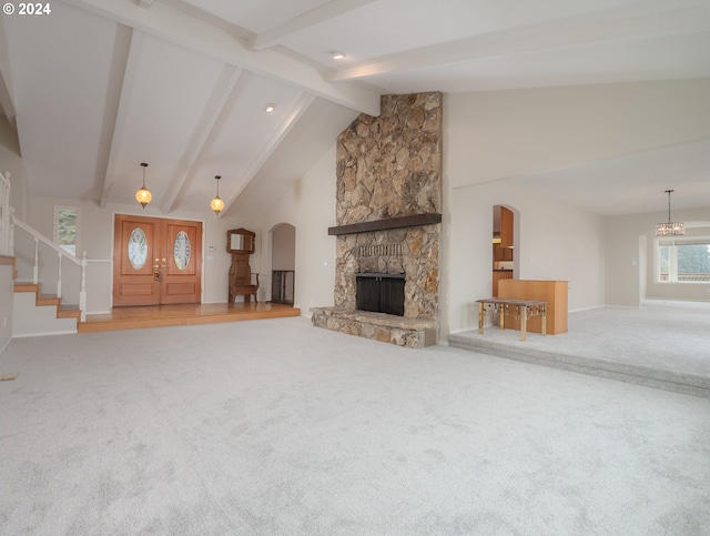 unfurnished living room featuring carpet, high vaulted ceiling, a fireplace, and beamed ceiling