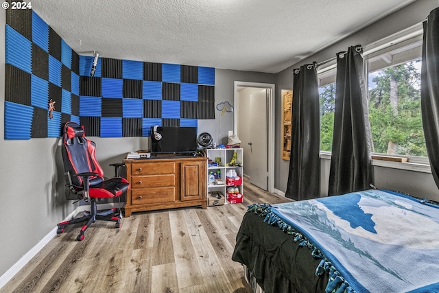 bedroom with a textured ceiling and wood-type flooring