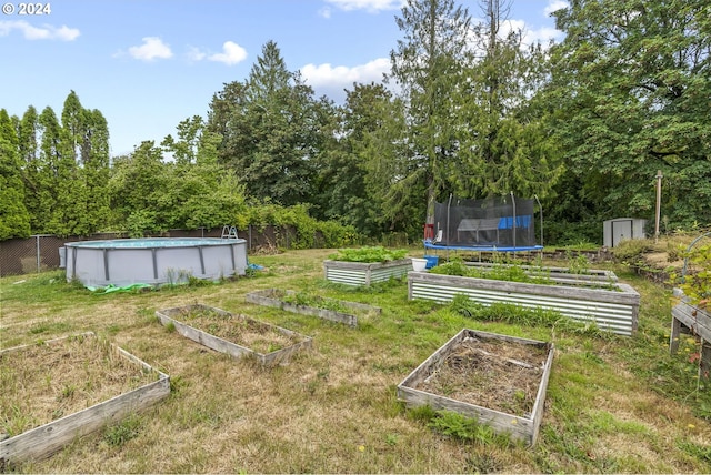 view of yard featuring a trampoline and a storage shed