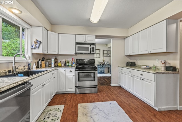 kitchen featuring dark hardwood / wood-style floors, sink, stainless steel appliances, and white cabinets