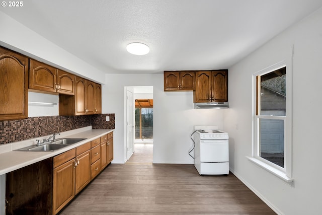 kitchen featuring white range with electric stovetop, sink, decorative backsplash, dark wood-type flooring, and a textured ceiling