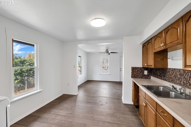 kitchen featuring sink, tasteful backsplash, a textured ceiling, dark hardwood / wood-style flooring, and ceiling fan