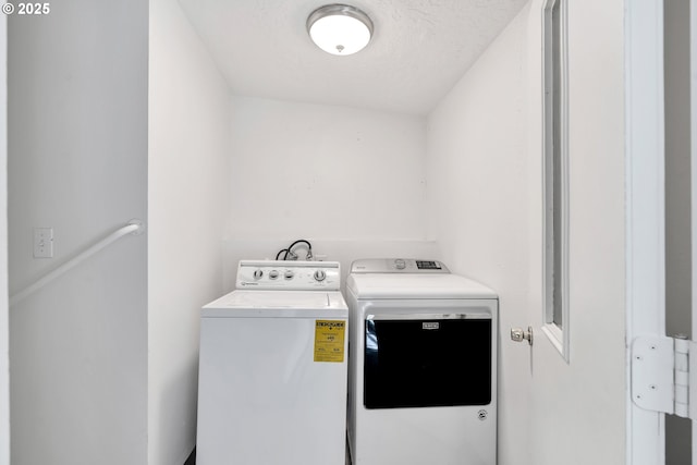 laundry area featuring washing machine and dryer and a textured ceiling