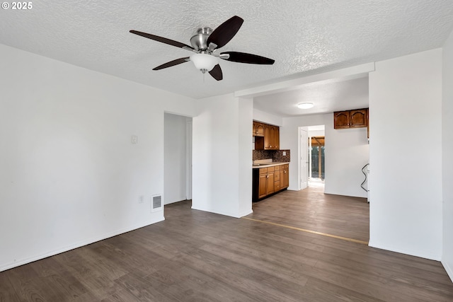 unfurnished living room with ceiling fan, dark hardwood / wood-style floors, and a textured ceiling