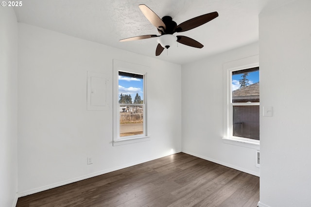 unfurnished room with hardwood / wood-style flooring, electric panel, and ceiling fan