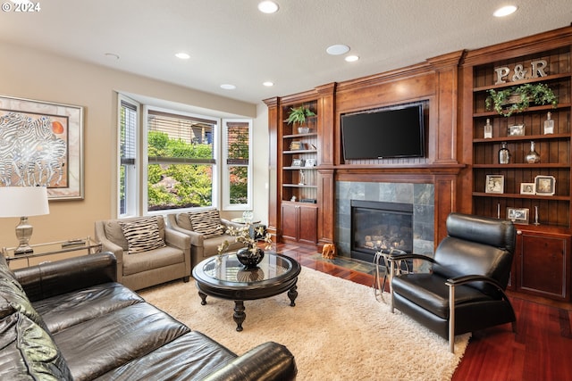 living room featuring a tile fireplace and dark hardwood / wood-style floors