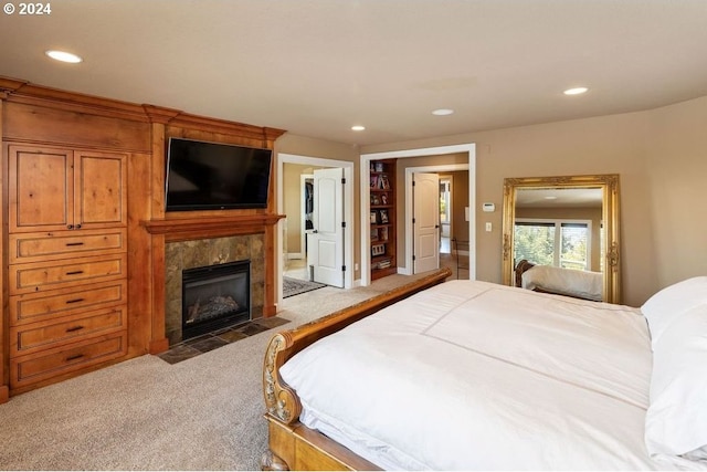 bedroom featuring a fireplace, a textured ceiling, and light colored carpet