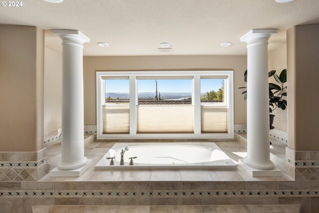 bathroom featuring tile patterned flooring, a textured ceiling, and tiled bath