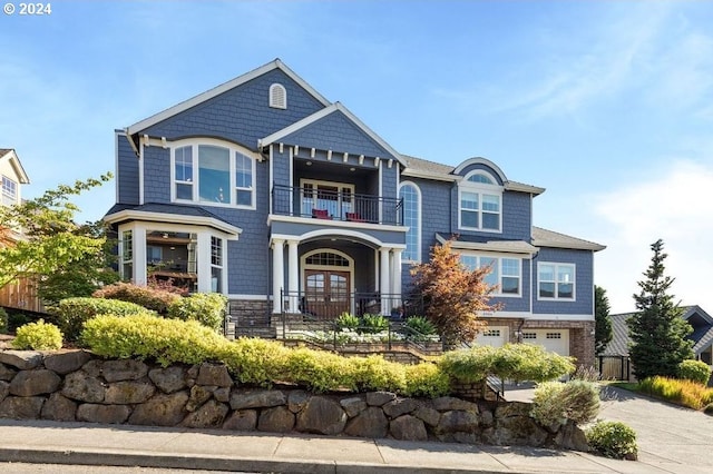 view of front of property with a balcony, a garage, and french doors